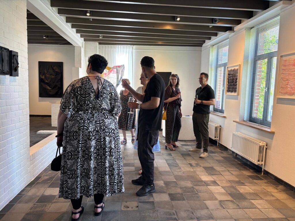 Bezoekers in gesprek tussen de werken in de galerie
